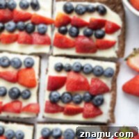 A festive 4th of July brownie dessert pizza with red strawberries and blue blueberries.