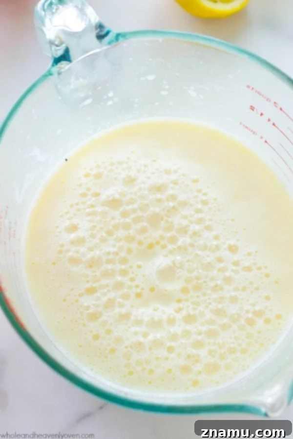 Buttermilk Magic: Just Two Ingredients 7 A rustic wooden board with baking ingredients including milk, lemon, flour, and a bowl of homemade buttermilk.