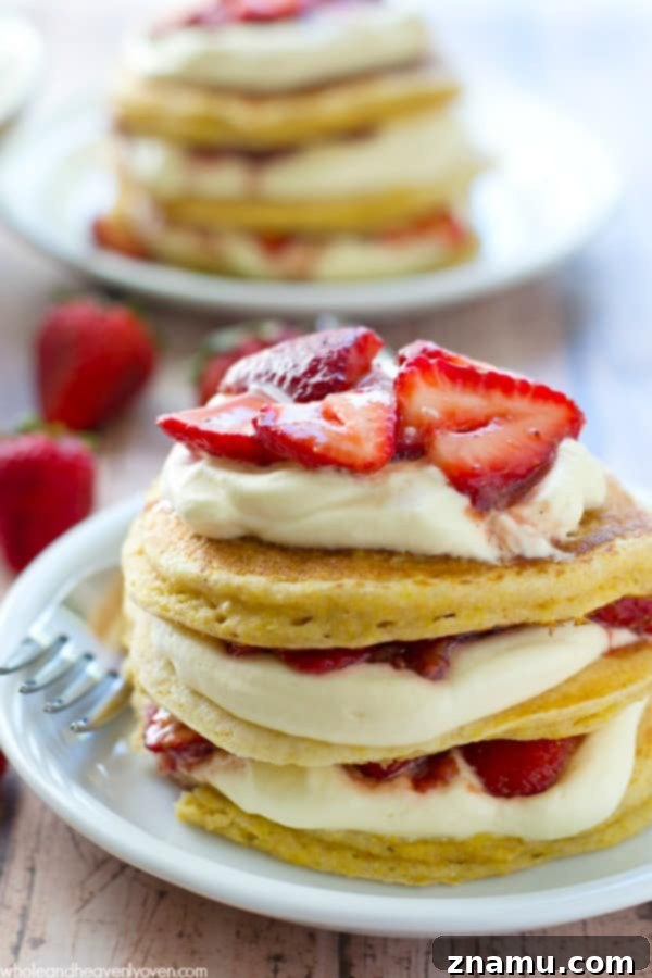 Colossal Buttermilk Blueberry Pancake 12 Layered pancake towers infused with strawberry shortcake flavors, featuring fresh strawberries and whipped cream, ideal for a showstopping brunch.