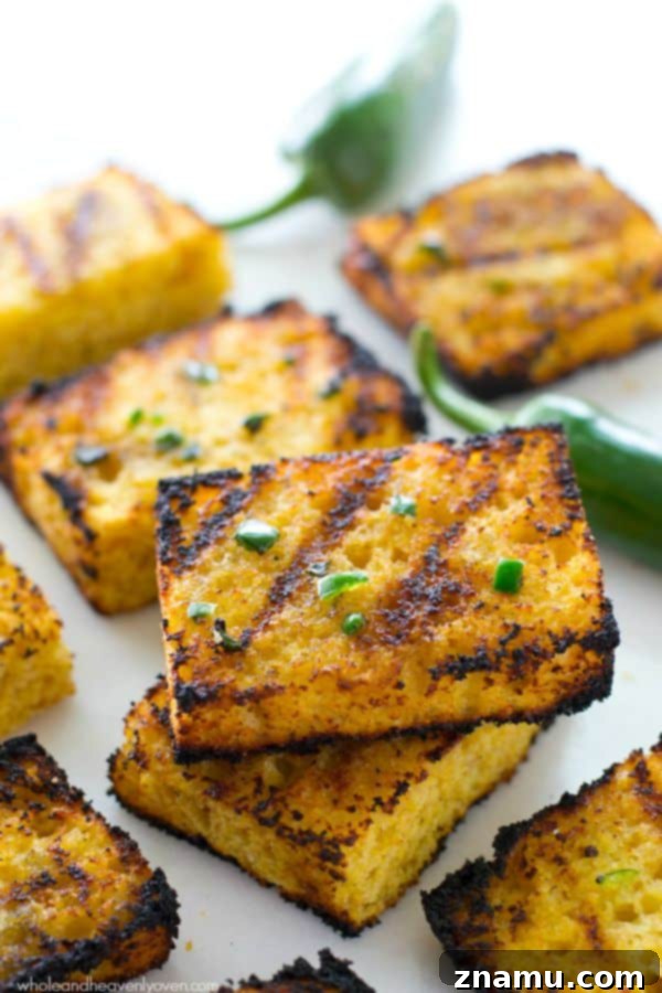 Honeyed Heat Griddle Cornbread 3 Up-close shot of a person spreading generous amounts of jalapeno honey butter onto sliced cornbread.