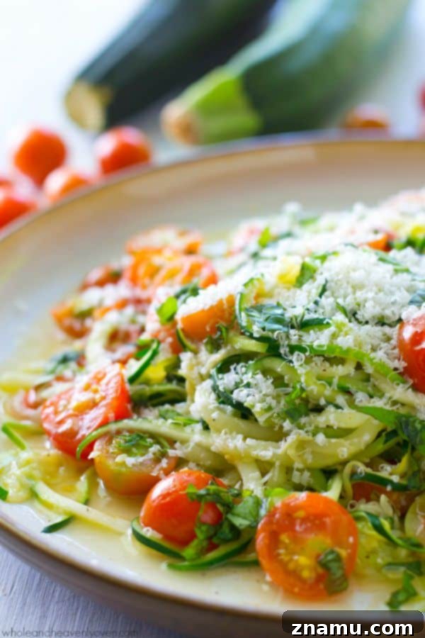 Light Parmesan Zoodles with Sweet Cherry Tomatoes 4 Freshly spiralized zucchini noodles in a bowl, showcasing their perfect texture and vibrant green color.