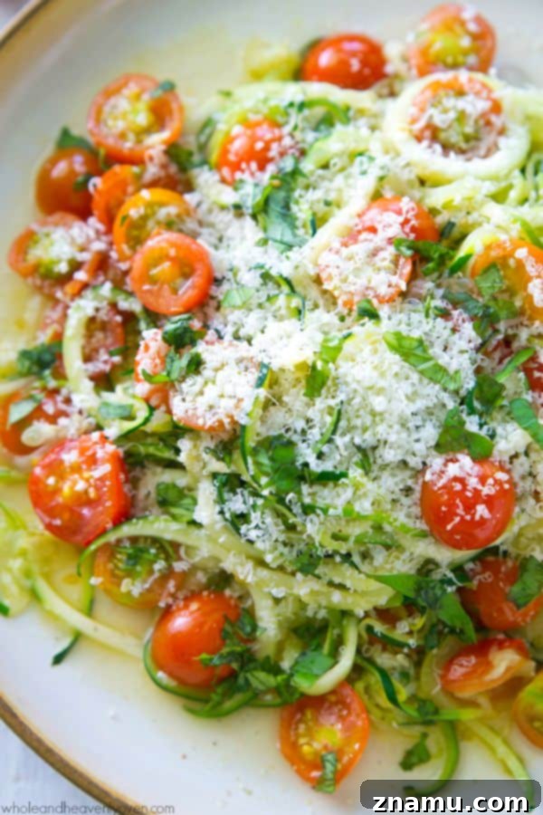 Light Parmesan Zoodles with Sweet Cherry Tomatoes 8 Abundant grated Parmesan cheese covering the zucchini noodles and cherry tomatoes in a pan, ready to be served.