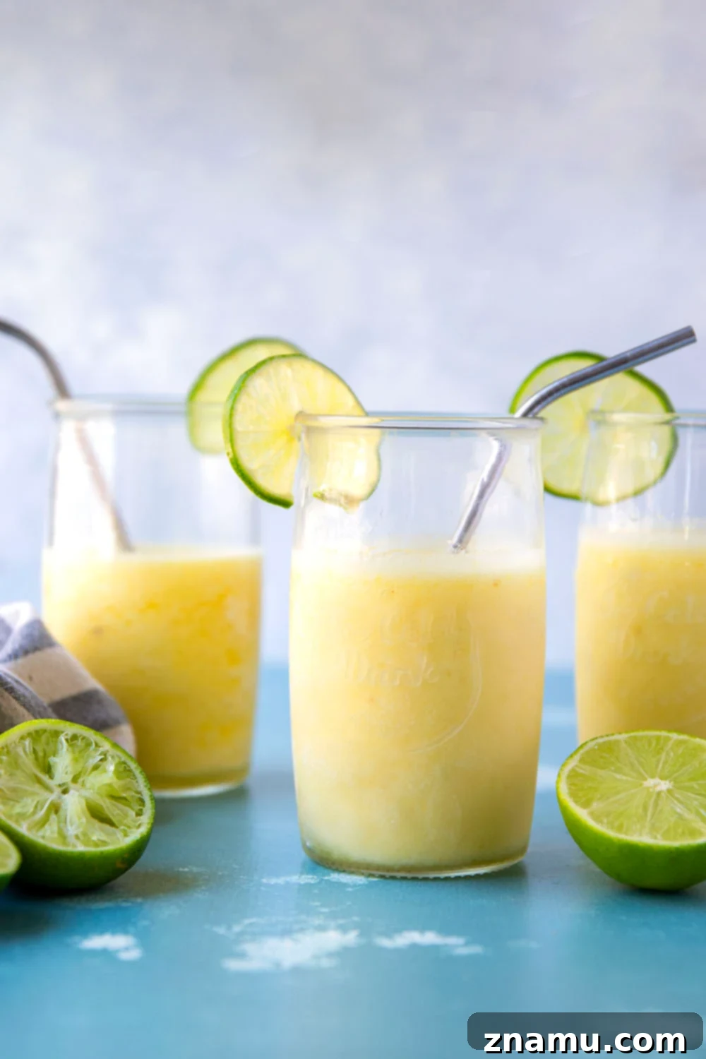 Tropical Pineapple Margarita Slush 6 A vibrant pineapple margarita slushy with a lime wheel and small umbrella, evoking a summer party atmosphere