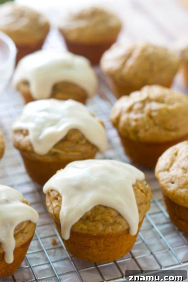 Glazed Zucchini Banana Muffins 3 Close-up of a glazed zucchini banana muffin stack
