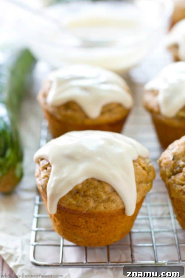 Glazed Zucchini Banana Muffins 4 Hand holding a perfectly glazed zucchini banana muffin
