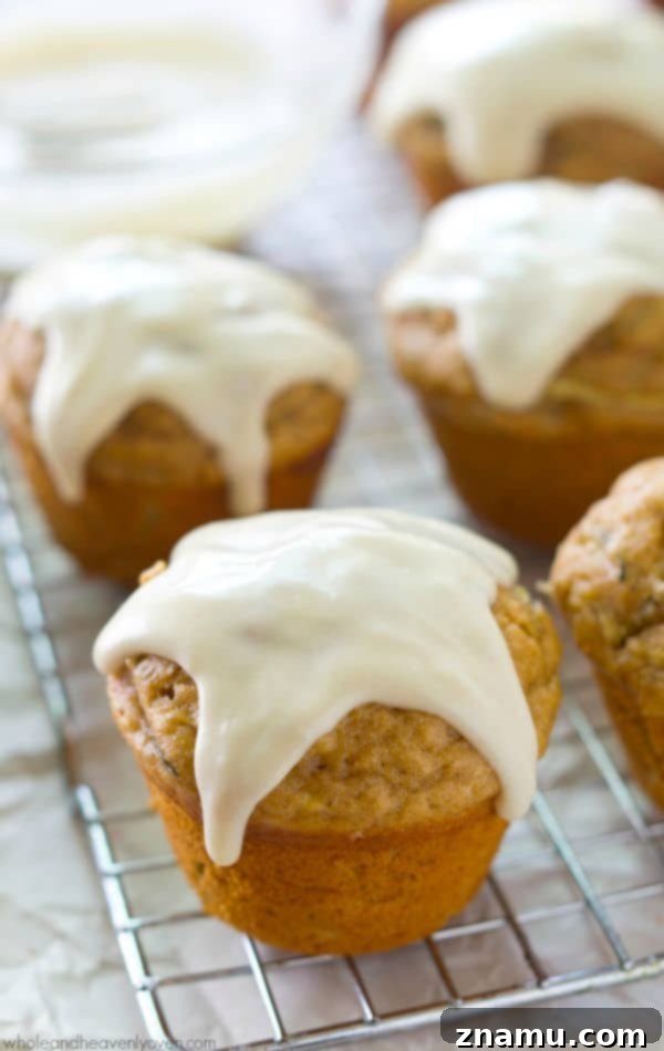 Glazed Zucchini Banana Muffins 7 Stack of glazed zucchini banana muffins on a wire rack