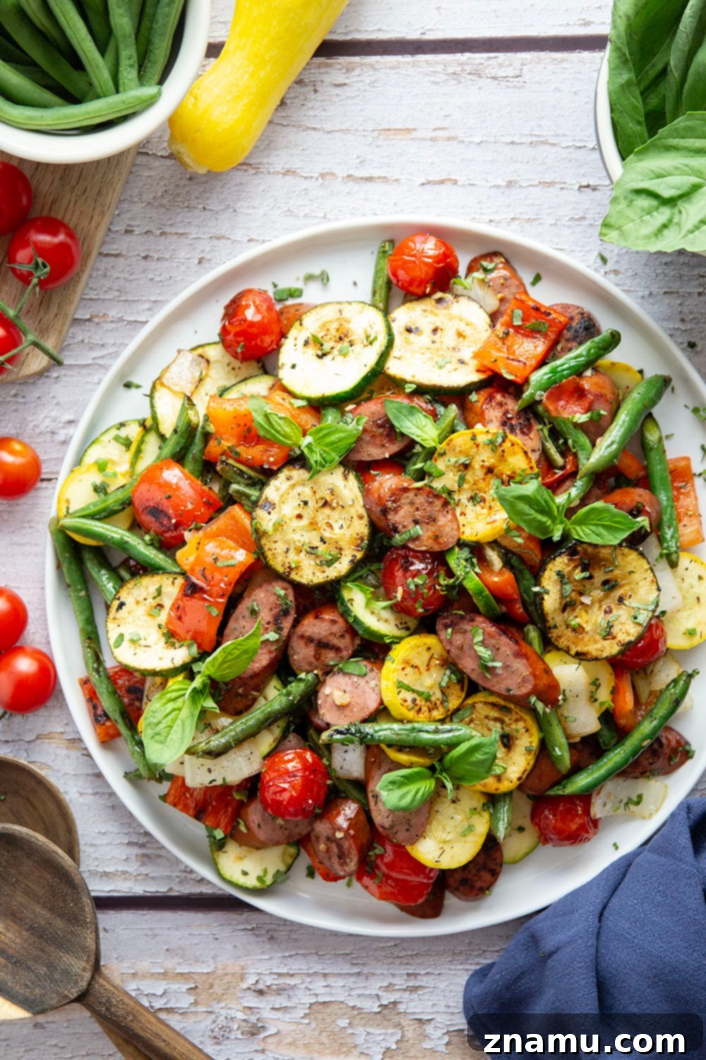 Zesty Marinated Grilled Summer Vegetables and Sausage 4 Assortment of fresh summer vegetables and sliced sausage marinating in a bowl.