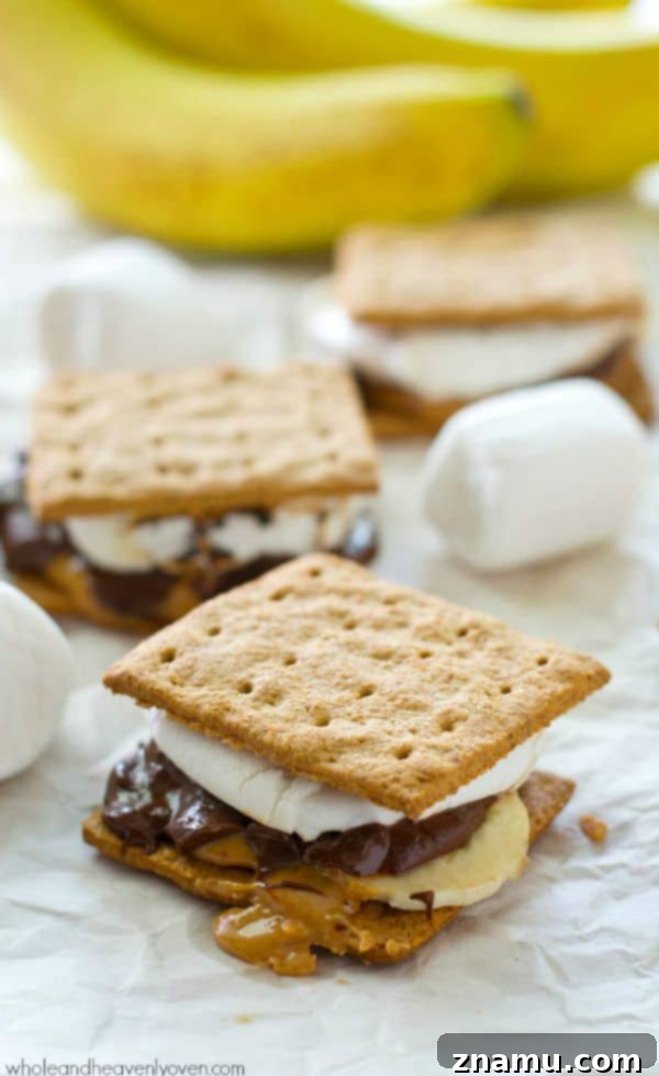 A close-up of a stacked peanut butter banana s'more with melted chocolate and marshmallow