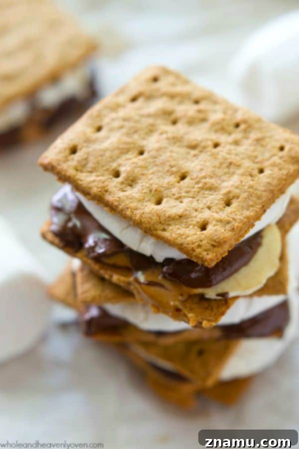 Hand holding a fresh peanut butter banana s'more oozing with melted ingredients