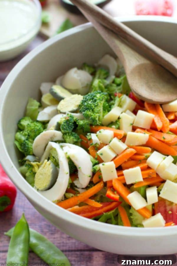 Delicious and healthy Rainbow Veggie Chef's Salad portioned onto a plate, with dressing.