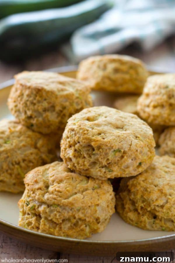 Savory Zucchini Parmesan Buttermilk Biscuits 6 A single zucchini Parmesan buttermilk biscuit with a bite taken out, showing the moist interior.