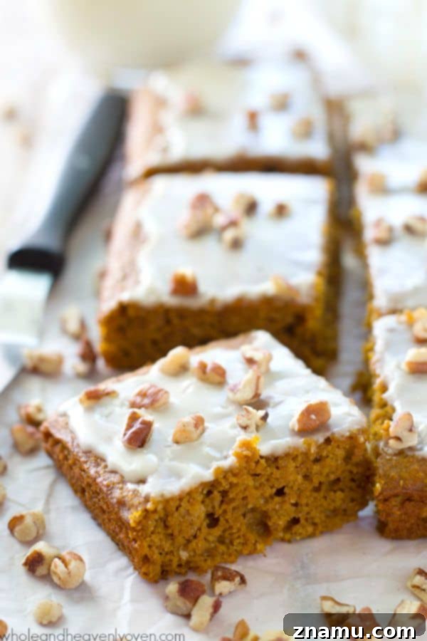 Velvet Pumpkin Spice Glaze Bars 7 Several moist pumpkin cake bars topped with smooth white glaze and chopped pecans.