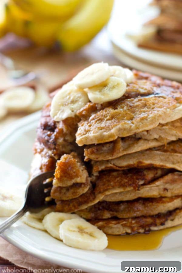 Bakery Banana Swirl Pancakes 8 A wide shot capturing multiple stacks of golden brown banana bread cinnamon roll pancakes on a platter, adorned with syrup and suggesting a hearty meal.