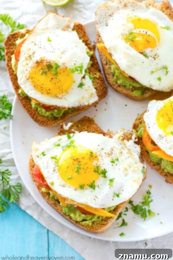 Cali Egg Avocado Toast 5 A close-up of a single slice of California-Style Fried Egg Avocado Toast, featuring a perfectly cooked fried egg with a runny yolk, ready to be enjoyed.