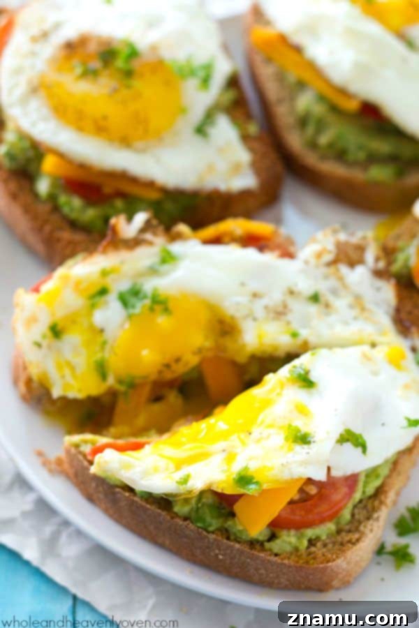 Cali Egg Avocado Toast 6 Several slices of California-Style Fried Egg Avocado Toast on a rustic wooden board, garnished with fresh parsley, highlighting its appealing presentation.