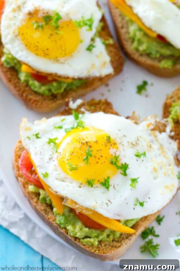 Cali Egg Avocado Toast 7 A hand reaching for a slice of California-Style Fried Egg Avocado Toast, emphasizing its inviting and ready-to-eat nature for a delicious meal.