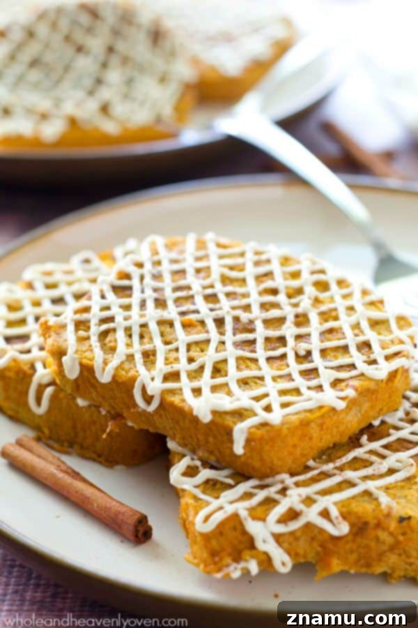 Decadent Pumpkin Cheesecake French Toast 4 A stack of Pumpkin Cheesecake French Toast with a spoon scooping a generous amount of cream cheese glaze.