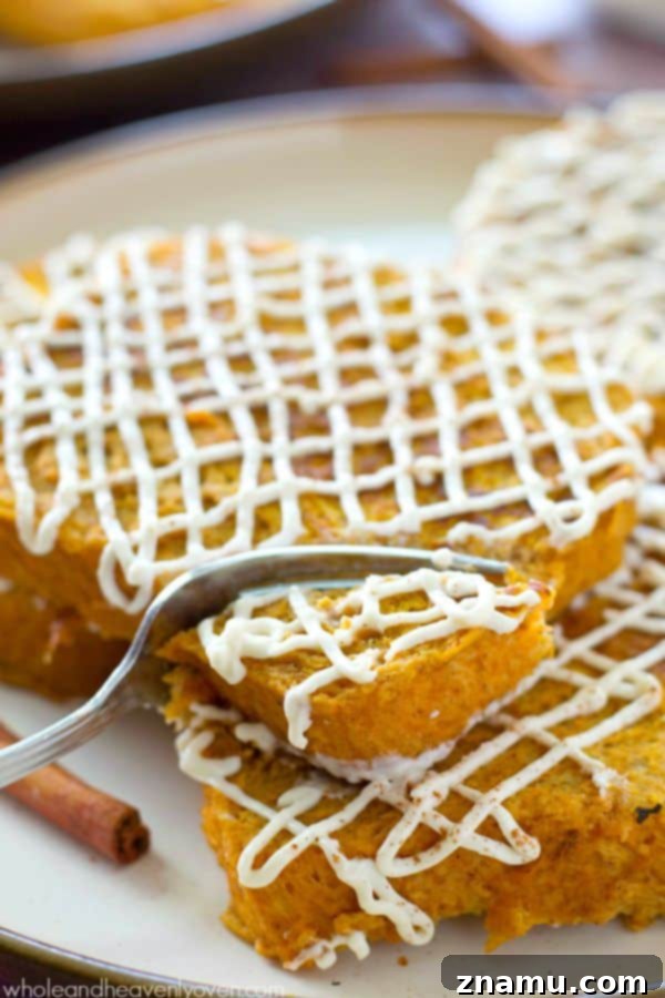 Decadent Pumpkin Cheesecake French Toast 6 A hand reaching for a slice of Pumpkin Cheesecake French Toast from a stack.