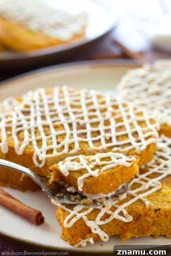 Decadent Pumpkin Cheesecake French Toast 8 A close-up of a stack of Pumpkin Cheesecake French Toast with a heavy drizzle of cream cheese glaze.