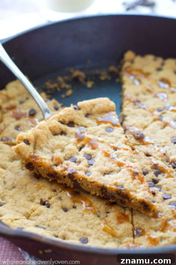 Gooey Flourless Caramel Chocolate Chip Skillet Cookie 4 The irresistible texture of the flourless skillet cookie, adorned with melted chocolate chips and golden caramel, promising pure dessert heaven. @WholeHeavenly