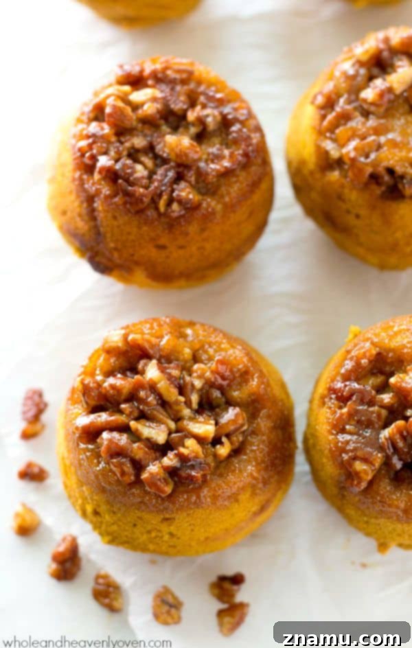 Gooey Pecan Pumpkin Flip Muffins 6 A stack of sticky pecan pumpkin muffins, garnished with a sprinkle of powdered sugar.