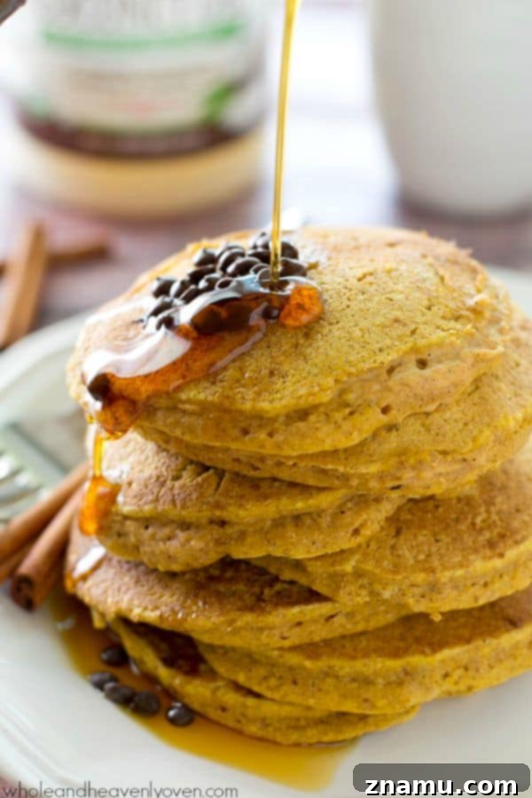 Autumn's Coconut Pumpkin Spice Pancakes 8 Maple syrup cascading over a stack of homemade pumpkin pancakes.