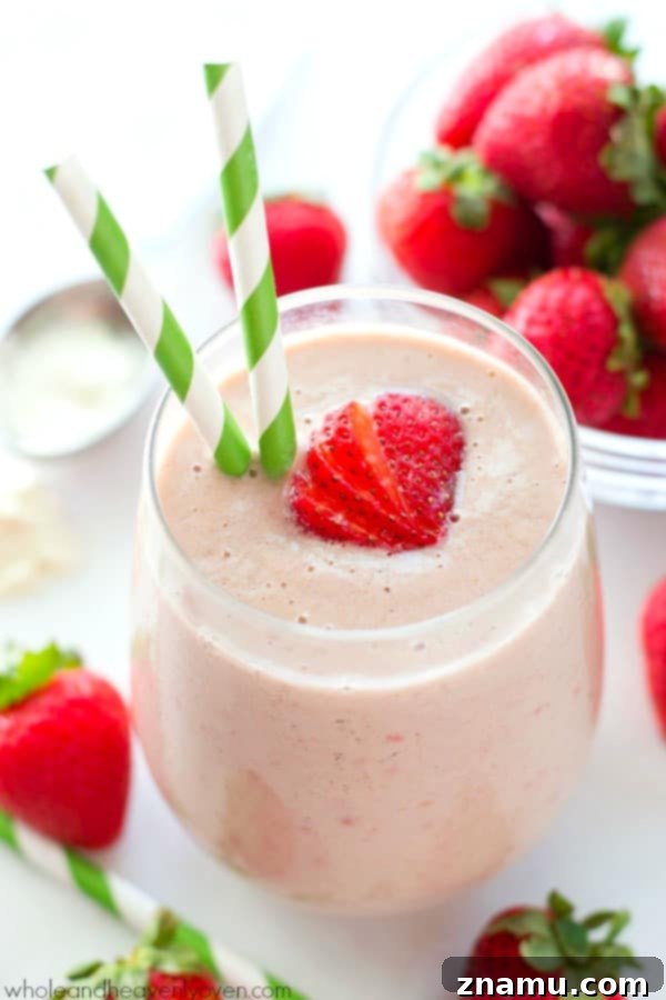 PB&J Power Up Smoothie 2 Creamy Peanut Butter and Jelly Protein Smoothie in a tall glass, garnished with a fresh strawberry.