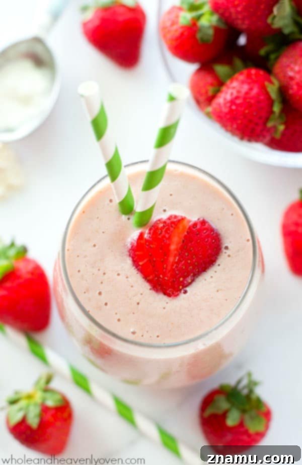 PB&J Power Up Smoothie 4 A glass of Peanut Butter and Jelly Protein Smoothie with fresh berries and a spoon, ready to be enjoyed.