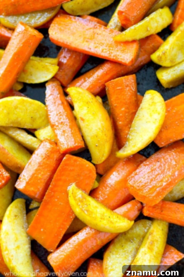 Moroccan Maple Caramelized Carrots and Apples 5 Close-up of roasted carrots and apple slices on a white plate, showcasing their tender texture and the inviting caramelized sheen from the maple syrup and spices.