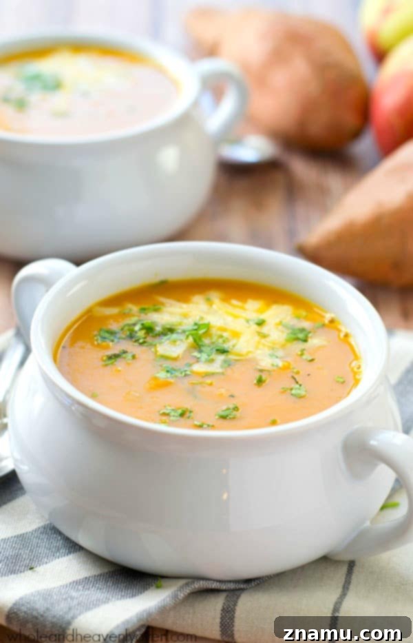 Spiced Sweet Potato Apple Bisque 3 A close-up shot of creamy sweet potato and apple soup, highlighting its smooth texture and vibrant color.
