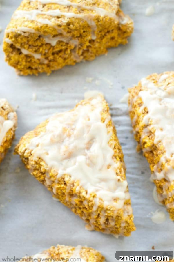Autumn Cafe Pumpkin Spice Scones 3 Close-up of a glazed pumpkin spice scone, ready to be enjoyed with a hot beverage.