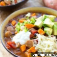 Hearty Slow Cooker Sweet Potato Sausage Chili 10 A finished bowl of Crockpot Sweet Potato Sausage Chili with vibrant toppings.