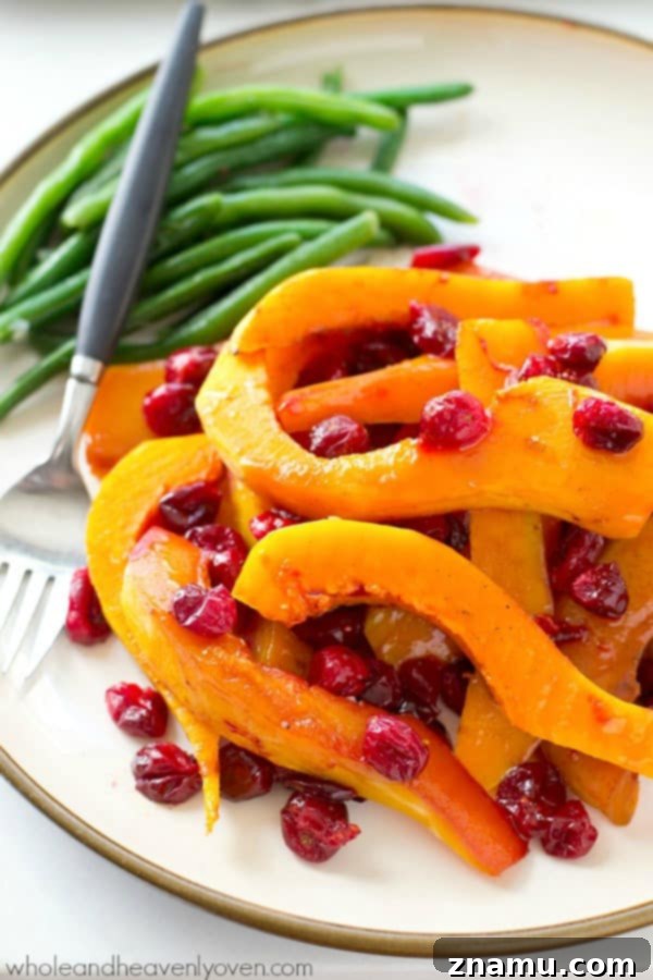 Butternut squash and cranberries are roasted to perfection in tons of honey and olive oil for one stunning side dish perfect for Thanksgiving or any fall dinner! @WholeHeavenly