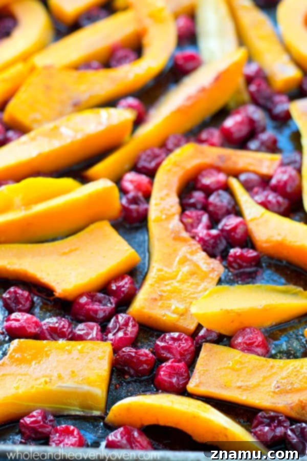 Butternut squash and cranberries are roasted to perfection in tons of honey and olive oil for one stunning side dish perfect for Thanksgiving or any fall dinner! @WholeHeavenly