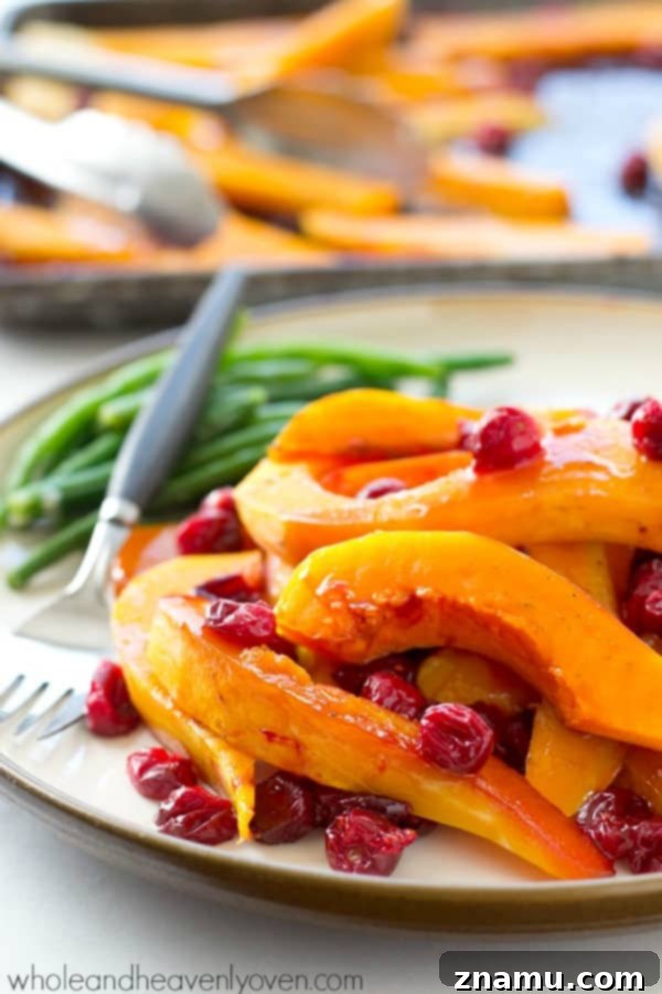Butternut squash and cranberries are roasted to perfection in tons of honey and olive oil for one stunning side dish perfect for Thanksgiving or any fall dinner! @WholeHeavenly