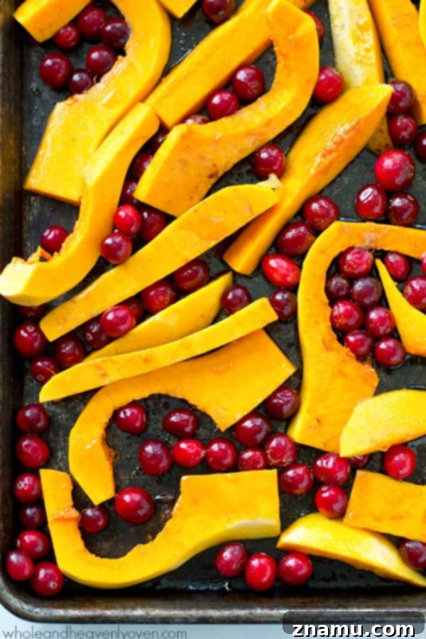 Butternut squash and cranberries are roasted to perfection in tons of honey and olive oil for one stunning side dish perfect for Thanksgiving or any fall dinner! @WholeHeavenly