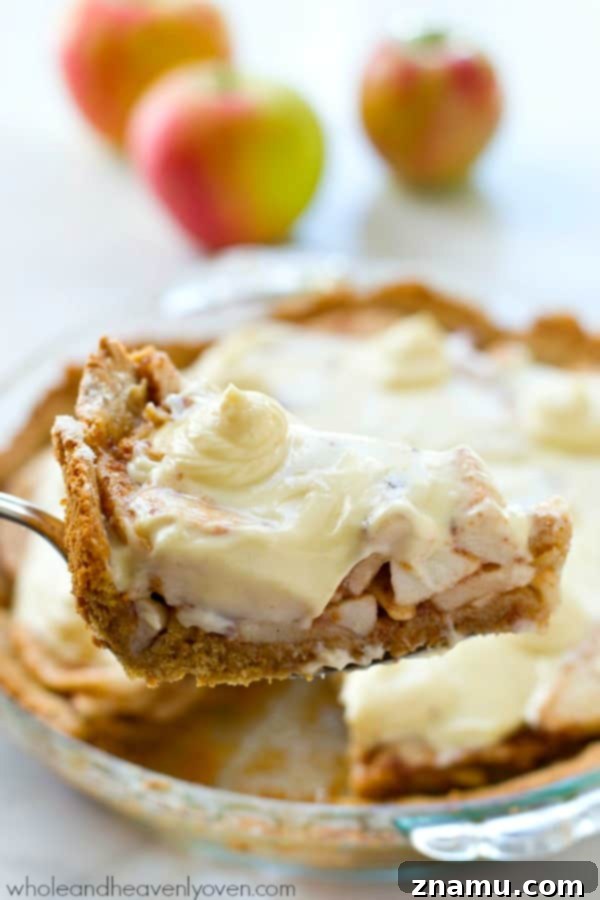 Cinnamon Sugar Apple Cheesecake Dream 7 A generous slice of Snickerdoodle Apple Cheesecake Pie on a wooden board