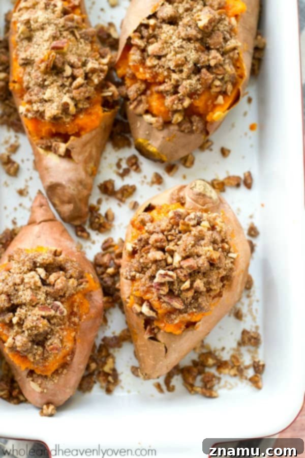 Creamy Twice-Baked Sweet Potatoes with Crunchy Pecan Streusel 3 Thanksgiving table setting with various side dishes, featuring a prominent plate of twice-baked sweet potatoes.