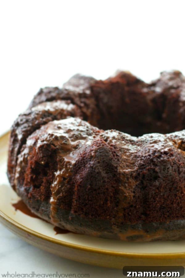 Decadent Birthday Chocolate Bundt Cake 3 Close-up of a slice of moist chocolate bundt cake with shiny ganache.