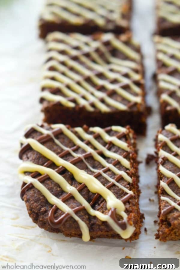 Decadent Triple Chocolate Chewy Bars 3 A close-up of chewy chocolate cookie bars, showing off their rich texture and melty chocolate chunks. A true delight for any sweet tooth. @WholeHeavenly