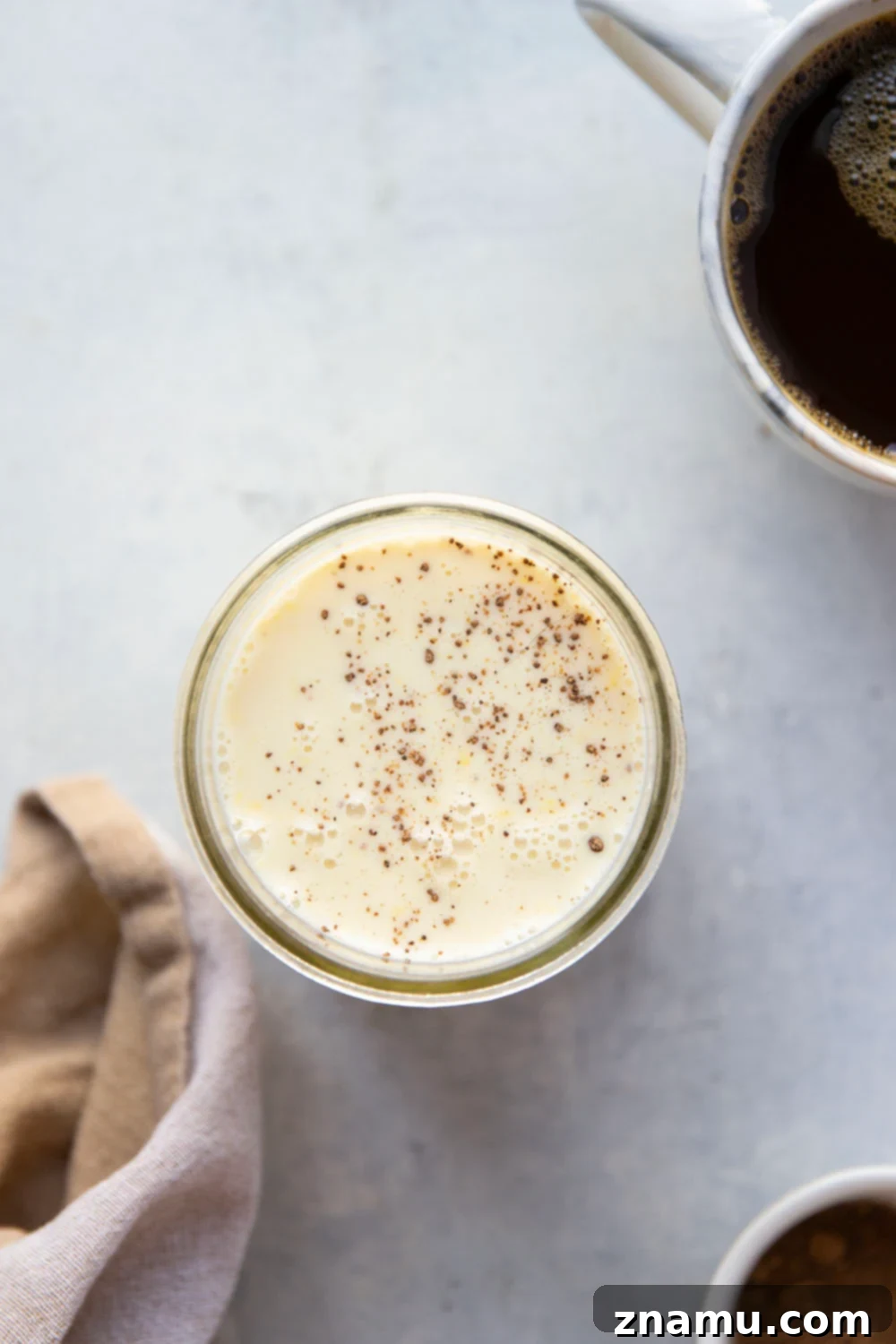 Spiced Eggnog Coffee Delight 6 Pouring homemade eggnog coffee creamer into a mug of coffee.