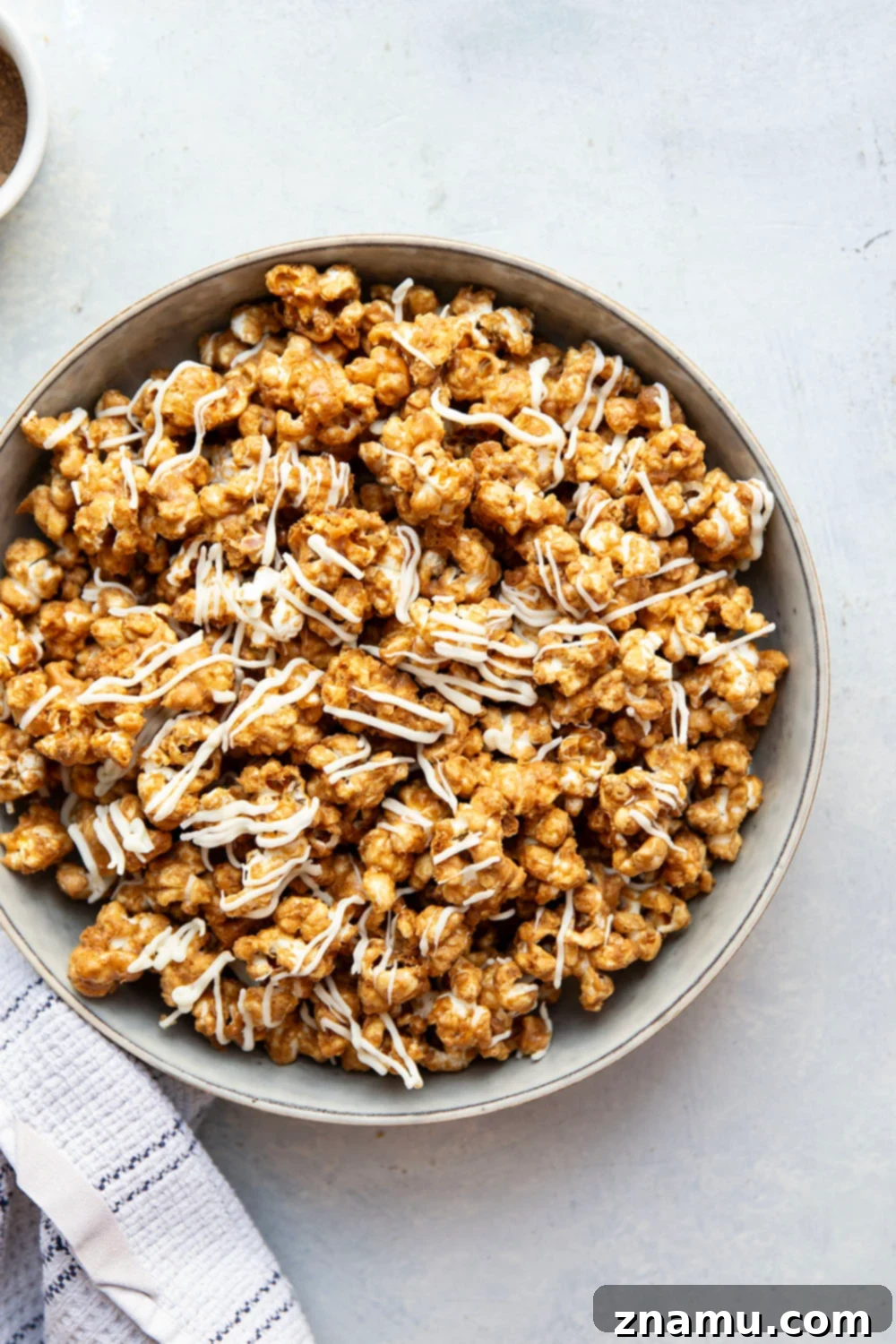 Gingerbread Caramel White Chocolate Crunch 2 Homemade gingerbread caramel popcorn coated in rich caramel and white chocolate, perfect for holiday snacking.