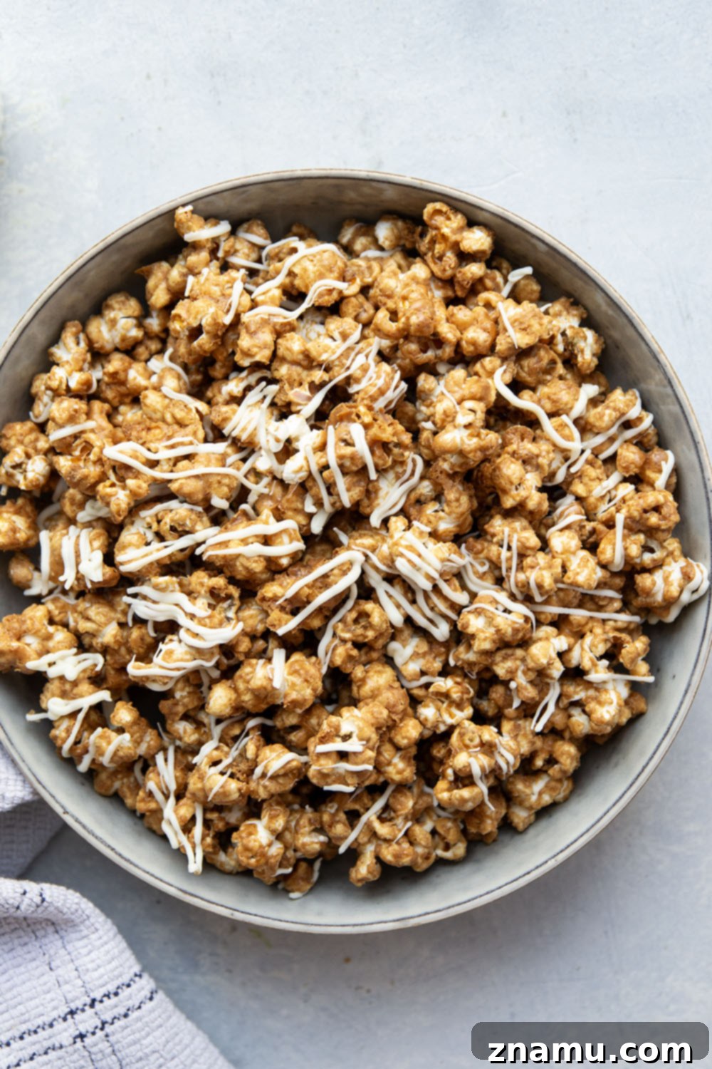 Gingerbread Caramel White Chocolate Crunch 4 Piles of gingerbread caramel popcorn on a baking sheet, ready for holiday festivities.