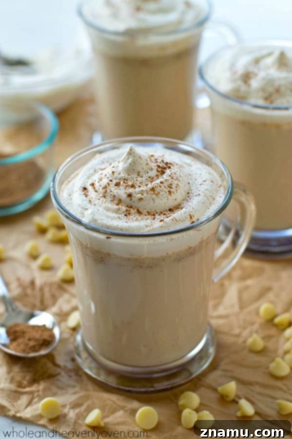 A steaming mug of chai-spiced white hot chocolate, garnished with whipped cream, made easy in a crockpot for cozy winter sips.