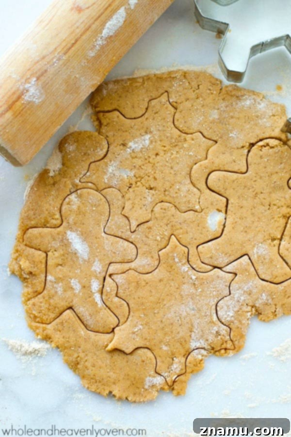 Coconut-Infused Eggnog Sugar Cookie Cut-Outs 8 Unbaked cut-out cookie dough on a parchment-lined baking sheet.