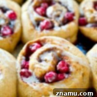 Dreamy Overnight Eggnog Cranberry Cinnamon Rolls 9 Overnight Eggnog Cranberry Cinnamon Rolls on a white plate