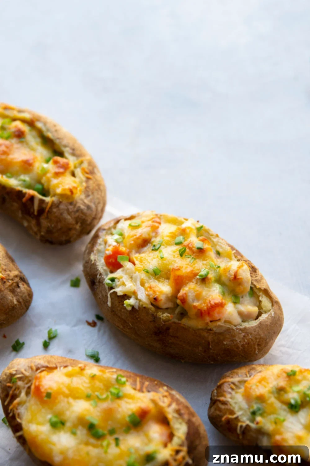 Loaded Chicken Pot Pie Potato Skins 3 Close-up of golden brown chicken pot pie potato skins with melted cheese.