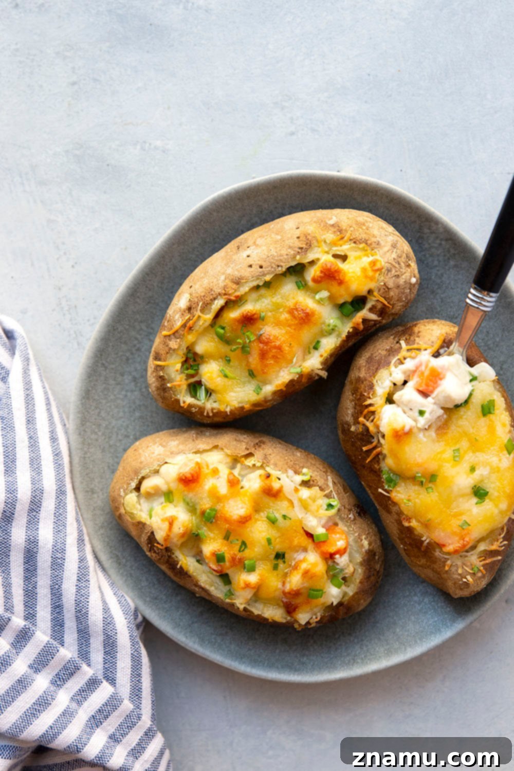 Loaded Chicken Pot Pie Potato Skins 5 Golden-brown chicken pot pie potato skins with herbs as garnish.