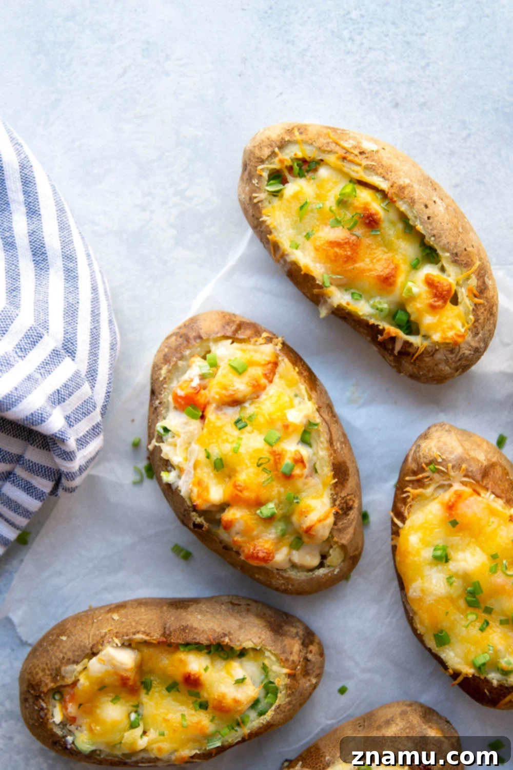 Loaded Chicken Pot Pie Potato Skins 6 Platter of several chicken pot pie potato skins, garnished with fresh herbs.