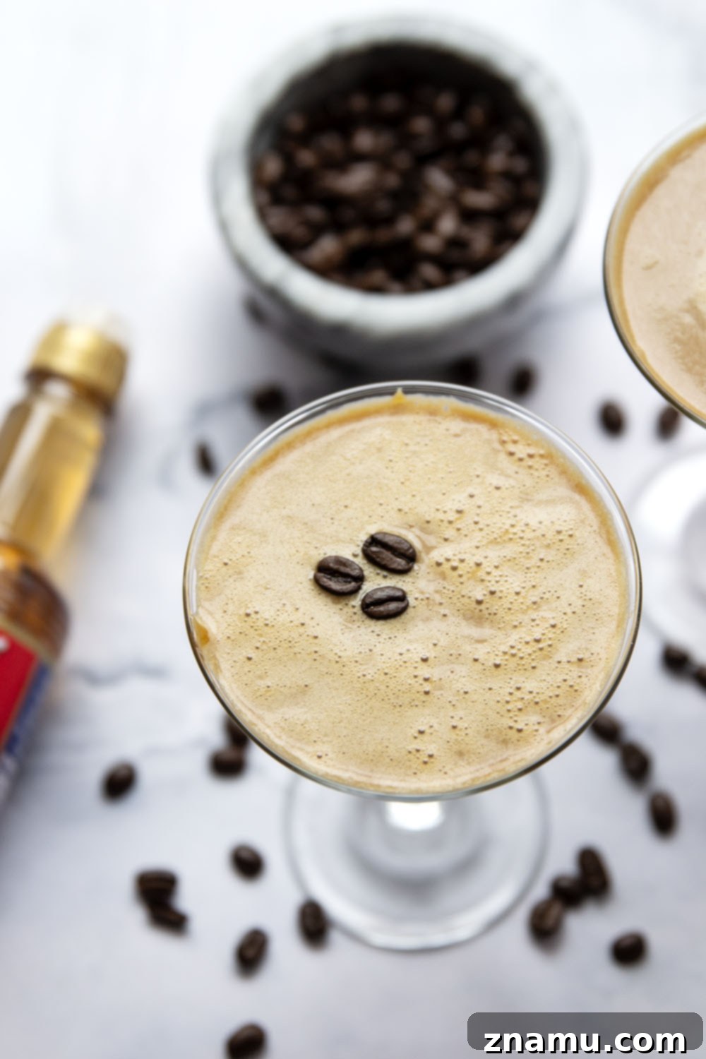 The Salted Caramel Espresso Martini 3 Two glasses of Salted Caramel Espresso Martini, garnished with coffee beans and beautiful caramel drizzles, ready to be served.